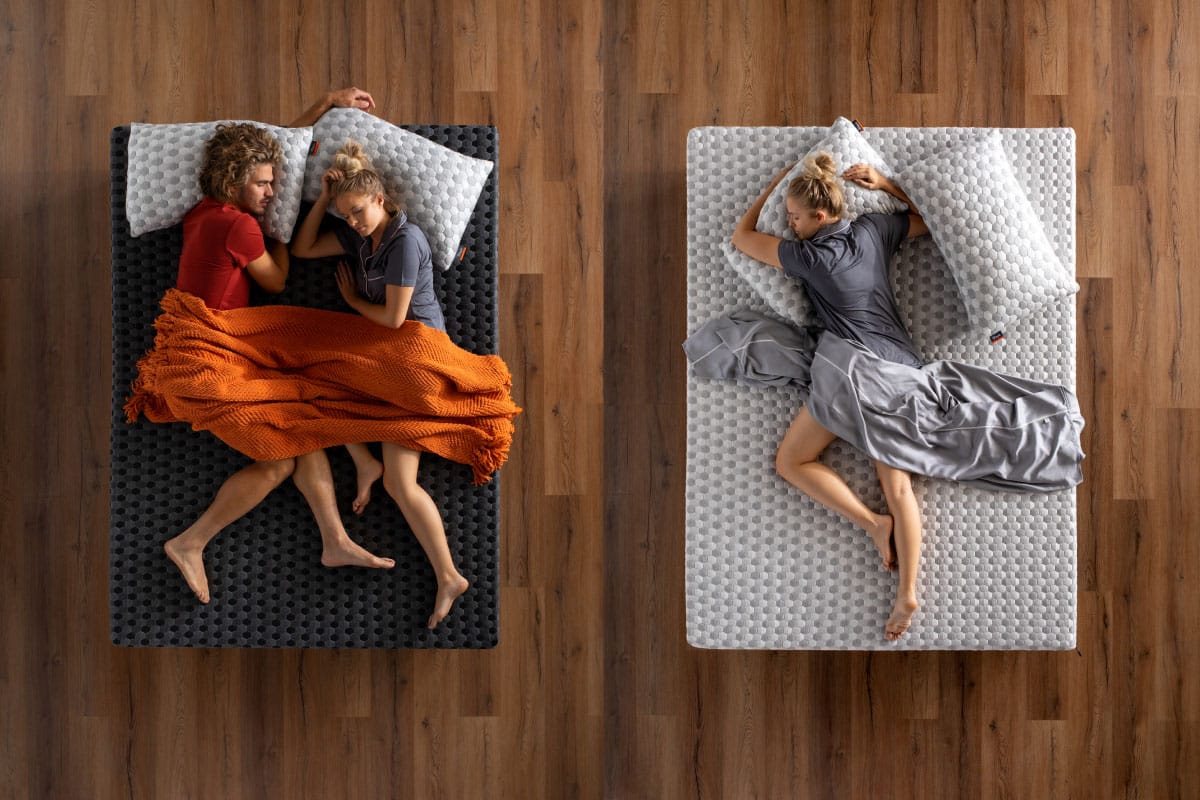 Couple laying on firm side and woman laying on soft side of memory foam mattress