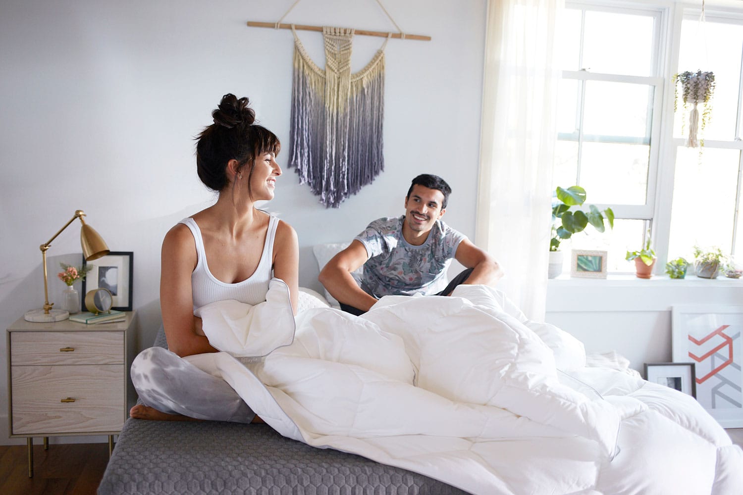 Couple sitting on bed with a comforter