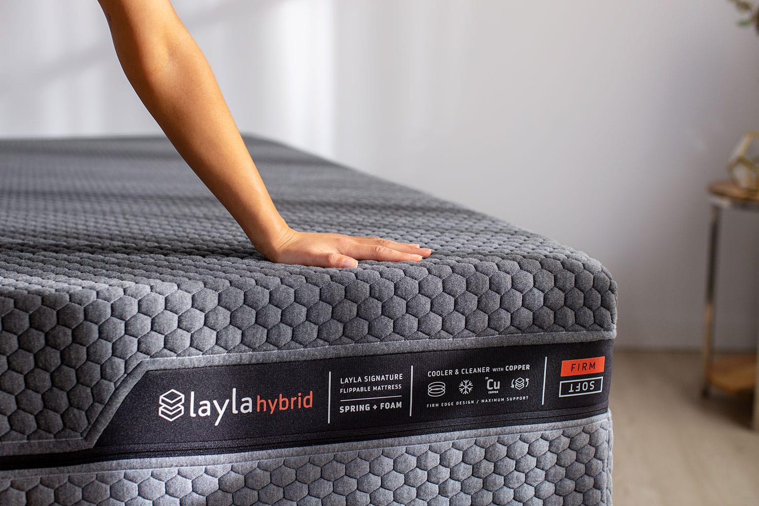 Hand pressing down on hybrid mattress